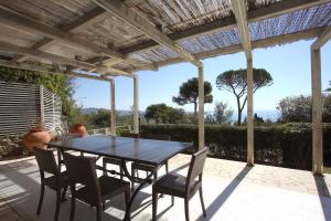 einen Tisch und Stühle auf einer Terrasse mit einer Pergola in der Unterkunft Villa Mareblu - Ansedonia in Ansedónia