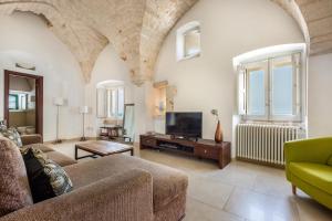 a living room with a couch and a tv at Casa degli Amici by BarbarHouse in Ostuni