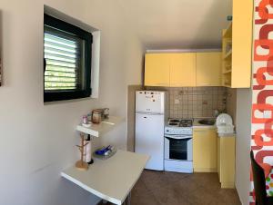 kuchnia z białą lodówką i żółtymi szafkami w obiekcie Apartman Barbara w Kotorze