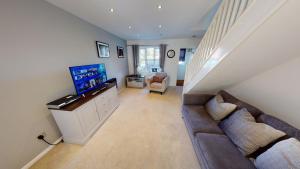 a living room with a couch and a flat screen tv at Victoria House in Hull