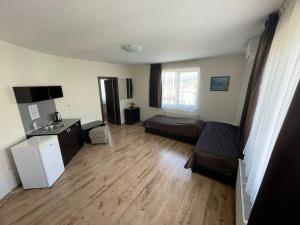 a living room with a bed and a refrigerator in it at Къща за гости Ради in Sapareva Banya +21 photos