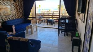 a living room with blue couches and a table and chairs at شاليه غرفتين بالمعمورة الشاطى على البحر صف ثان in Alexandria