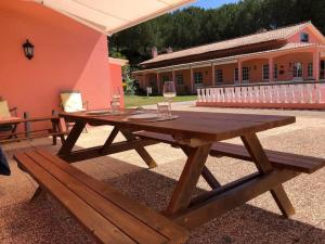 un tavolo da picnic in legno con 2 bicchieri di vino di Quinta com piscina exclusiva e experiências únicas a Aveiras de Baixo