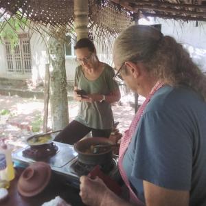 Yaluwa Tourist Rest & cooking class في أنورادابورا: رجل وامرأه يبحثون في جوالاتهم