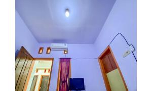a room with a mirror and a tv and a window at Griya Asri Syariah Mitra RedDoorz in Rogojampi