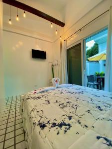 a bedroom with a large bed and a balcony at Sparrow's Nest in Panglao