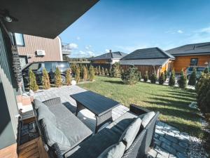 a patio with a table and chairs on a backyard at Green Shine Apartment, By Cohost in Palanga