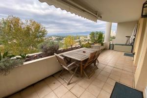 eine Terrasse mit einem Tisch und Stühlen auf dem Balkon in der Unterkunft Quiet apartment with terrace & pool - Cannes in Cannes