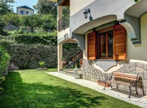 un banc assis à l'extérieur d'une maison avec une fenêtre dans l'établissement Villa dei Fiori - Exclusive Villa with garden in Sorrento Coast, à Vico Equense