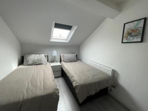 two beds in a small room with a window at Hosted By Ryan - Anfield Apartments in Liverpool