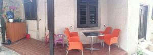 a small patio with orange chairs and a table at Apartman Zepina in Pula