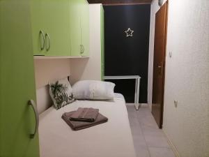 a small bedroom with a bed with a towel on it at Apartman Zepina in Pula