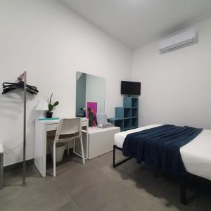 1 dormitorio con cama, escritorio y mesa en fico d'india, en Spadafora