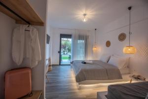 1 dormitorio con 1 cama y puerta que da a un patio en Alios Gaia - Seaside Apartments, en Nikiti