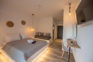 a bedroom with a bed and a table and a desk at Alios Gaia - Seaside Apartments in Nikiti