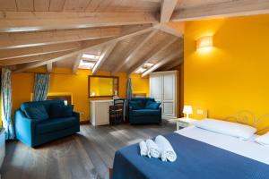 1 Schlafzimmer mit einem blauen Bett und 2 Stühlen in der Unterkunft Gemma Rentals in Garda