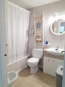 La salle de bains blanche est pourvue de toilettes et d'un lavabo. dans l'établissement Apartamento Pepa Mar y Montaña, à Peñíscola
