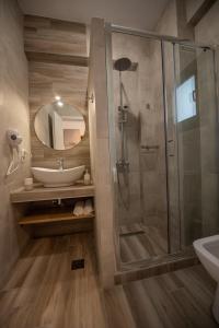 a bathroom with a shower and a sink and a mirror at Alios Gaia - Seaside Apartments in Nikiti