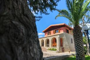 アンドリアにあるB&B Villa Adrianaの前にヤシの木がある家