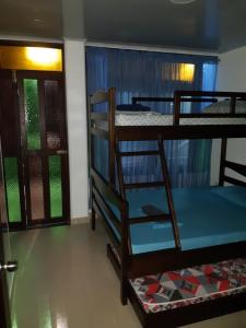 a room with two bunk beds and a door at Hospedaje casa Blanca, la mejor opción en Guaviare in San José del Guaviare