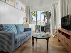 a living room with a blue couch and a table at H10 Ocean Suites in Corralejo