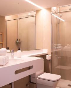 a bathroom with a sink and a shower and a toilet at Apartamentos Llobet Ibiza in Ibiza Town