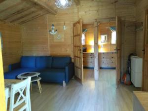 a living room with a blue couch in a cabin at POD ŚWIERKAMI domki letniskowe Wisełka in Wisełka