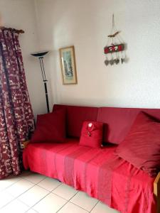 Sofá rojo en una habitación con cama roja en Charmant Studio Duplex 26m2 à la montagne, en Praz-sur-Arly