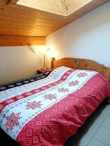 Un dormitorio con una cama con una manta. en Charmant Studio Duplex 26m2 à la montagne, en Praz-sur-Arly