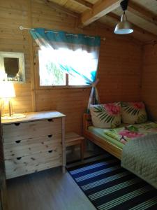 a bedroom with a bed and a desk in a cabin at POD ŚWIERKAMI domki letniskowe Wisełka in Wisełka