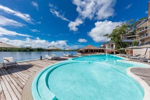 a large swimming pool with chairs and the water at Ramada Resort by Wyndham Port Vila in Port Vila