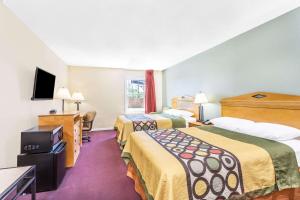 a hotel room with two beds and a flat screen tv at Super 8 by Wyndham Manning in Manning