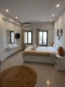 a bedroom with a large bed and two windows at SORINA Beloved Rooms in Spetses