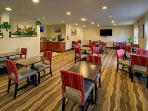 a restaurant with tables and chairs and a television at Comfort Inn Brunswick in Brunswick