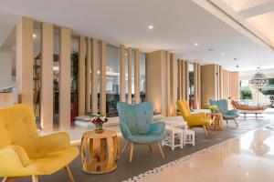 a lobby with colorful chairs and a table at Sealine Beach, a Murwab Resort in Mesaieed