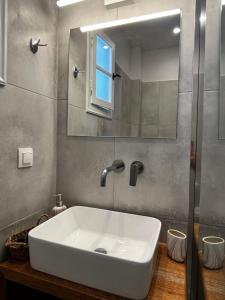 a bathroom with a white sink and a mirror at SORINA Beloved Rooms in Spetses