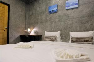 una camera da letto con un letto bianco con due asciugamani sopra di The Simple Koh Yao Noi a Ko Yao Noi