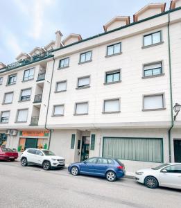 un grupo de coches estacionados frente a un edificio en Sarnadela, en Caldas de Reis