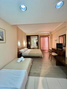 a hotel room with two beds and a desk at Saint George Hotel in Asprovalta