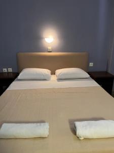 a bed with two white towels on it at Saint George Hotel in Asprovalta