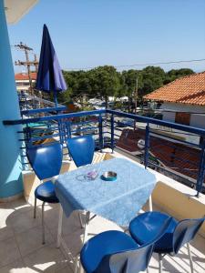 a blue table and chairs on a balcony at Kassandros Studios - Hanioti Halkidiki in Hanioti