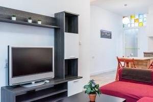 sala de estar con TV y sofá rojo en Céntrico y tranquilo apartamento Realejo, en Granada