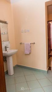a bathroom with a sink and a towel at Lux Suites Makao Rossyln Apartments in Nairobi