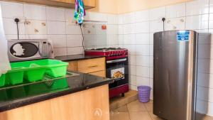 y cocina con nevera y microondas. en Lux Suites Makao Rossyln Apartments Ruaka, en Nairobi