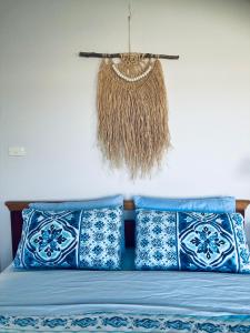 1 cama con almohadas azules y blancas y una cesta colgante en House on the hill, en Port Campbell