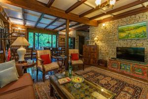 a living room with a fireplace and a tv at StayVista at The Kathguni House in Manāli