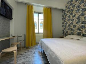 a bedroom with a bed and a window with yellow curtains at Moshi Moshi in Rome
