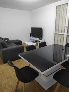 a living room with a table and chairs at Appartement 70m² Pierrelatte Cosy, NETFLIX+WIFI in Pierrelatte