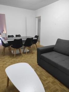 een woonkamer met een bank, stoelen en een tafel bij Appartement 70m² Pierrelatte Cosy, NETFLIX+WIFI in Pierrelatte