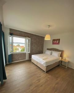 a bedroom with a large bed and a window at Cunda Kordon Otel in Ayvalık